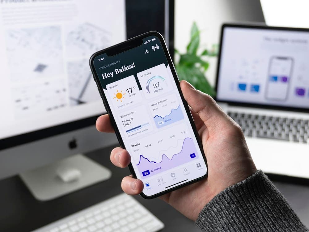Hand holding a smartphone showing a dashboard app